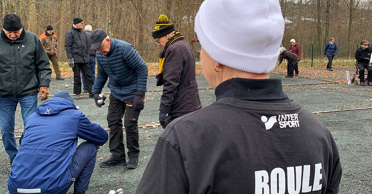 Ett gäng äldre personer spelar boule.
